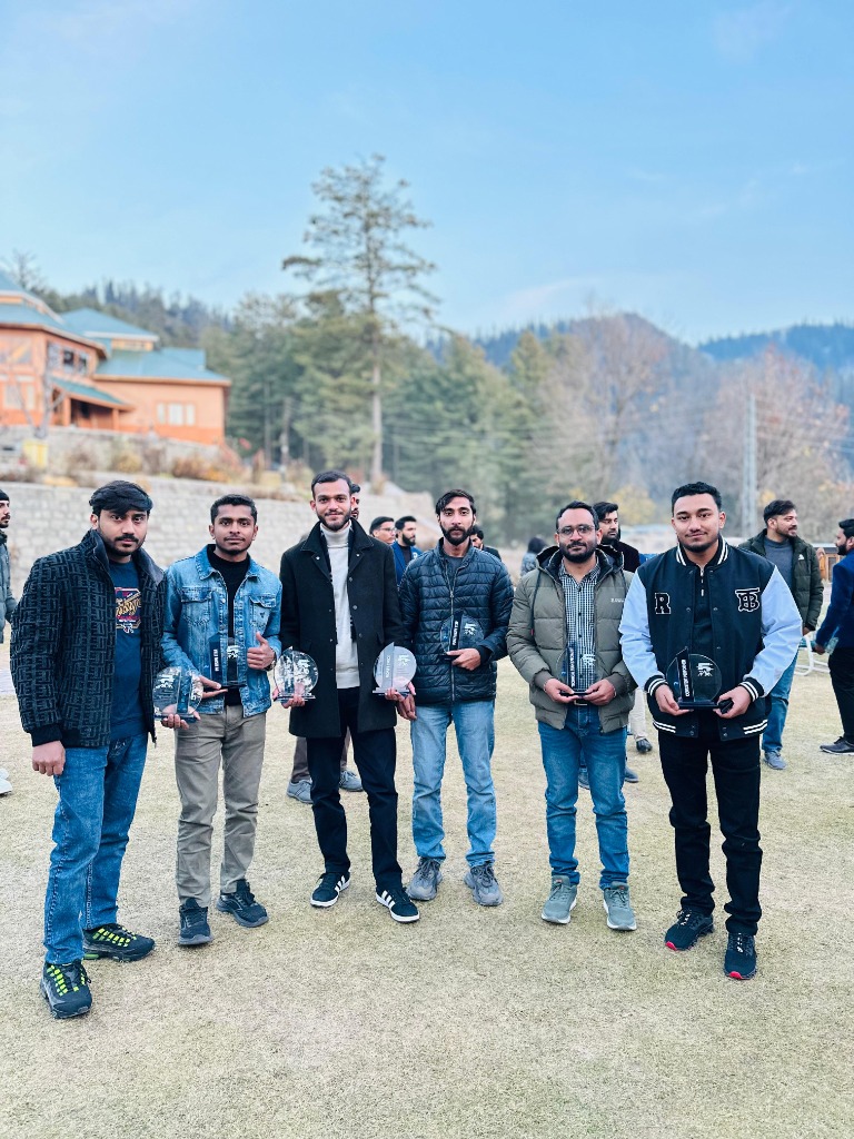 Muhammad Mohiz with Rankviz award winners holding trophies at mountain retreat
